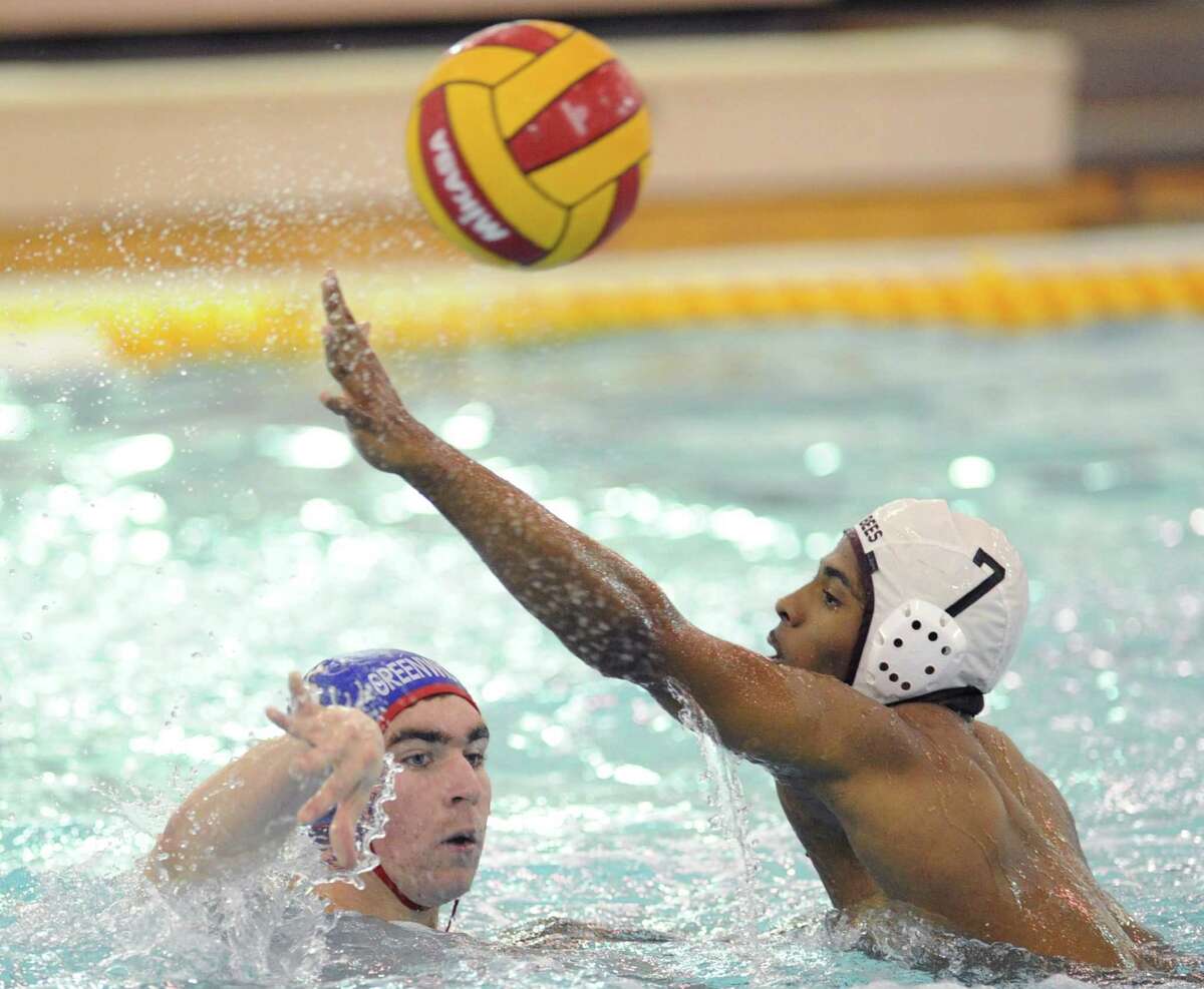 At left, Julian Fraser of Greenwich High School passes while being pressured by Kenny Joseph (# 7) of St. Benedict's Prep during the 39th Annual Cardinal Water Polo Tournament at Greenwich High School, Saturday, Oct. 19, 2013.