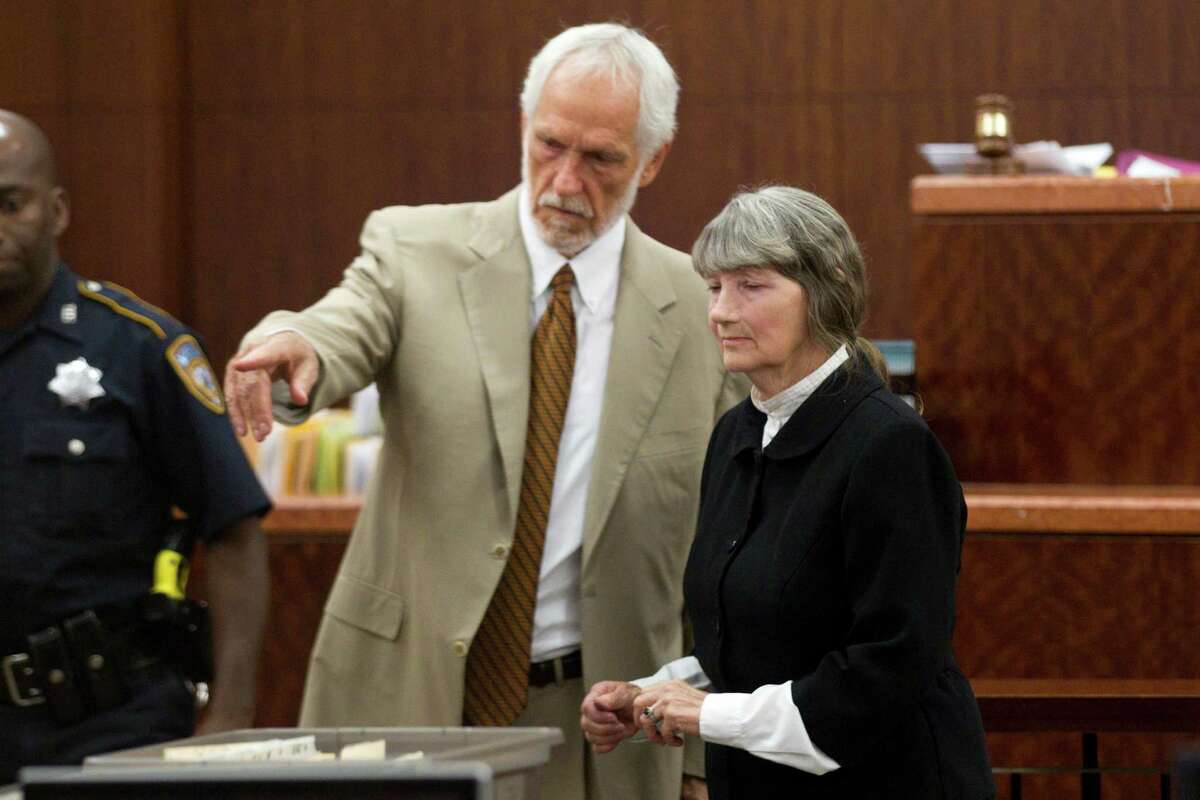 Attorney James Stafford, left, shows Carolyn Krizan-Wilson to her seat as she appears in court Wednesday, Oct. 23, 2013, in Houston. Krizan-Wilson pled guilty in the 1985 shooting death of her husband, Roy Joe McCaleb. The murder was a cold case for years. She was arrested in 2008. She was sentenced to 10 years probation and six months in jail