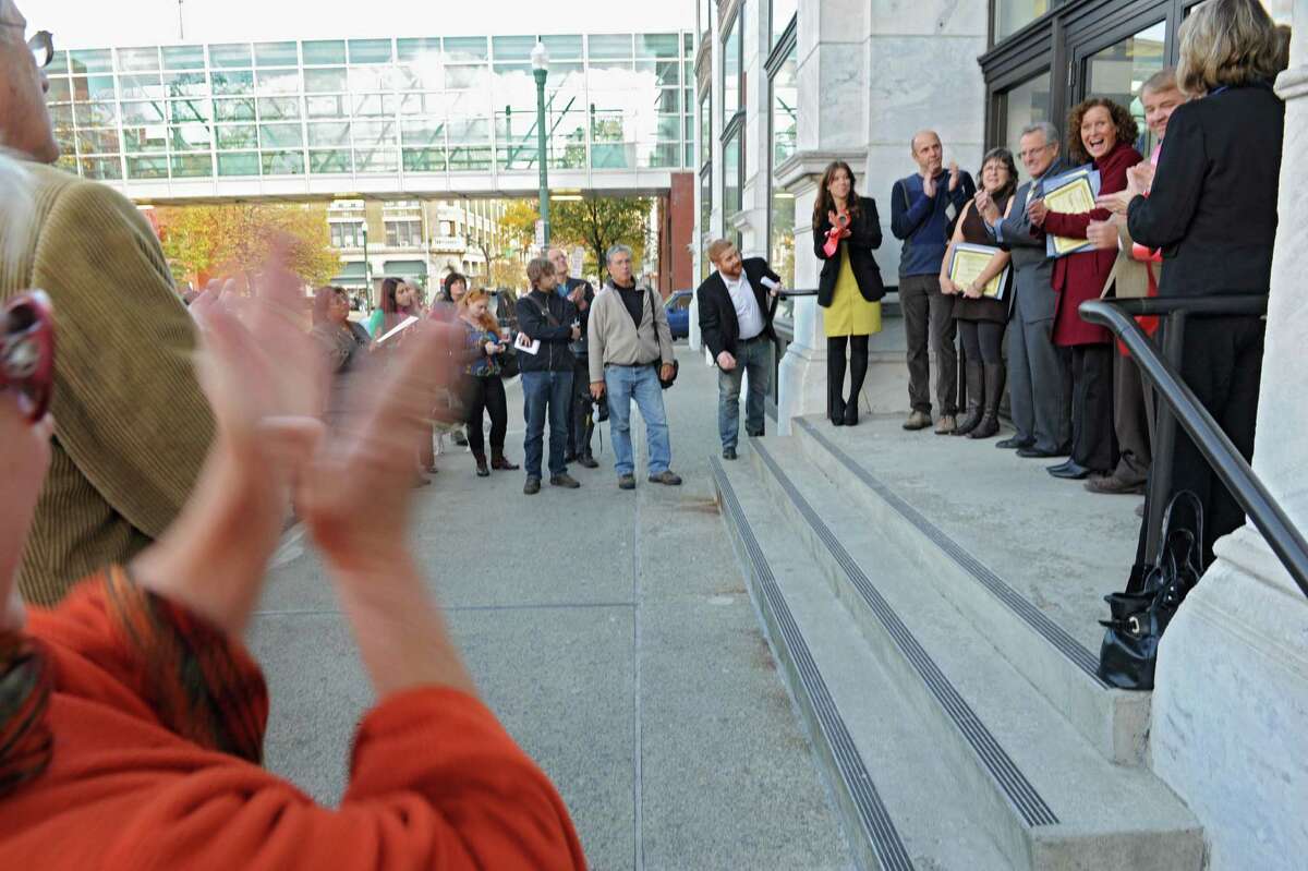 People clap during a ribbon cutting ceremony for three new stores in the landmark Troy Frear's Cash Bazaar building on Wednesday, Oct. 23, 2013, in Troy, N.Y. The new stores are E Ko Logic, Trojan Horse Antiques and Modern on the Hudson. (Lori Van Buren / Times Union)