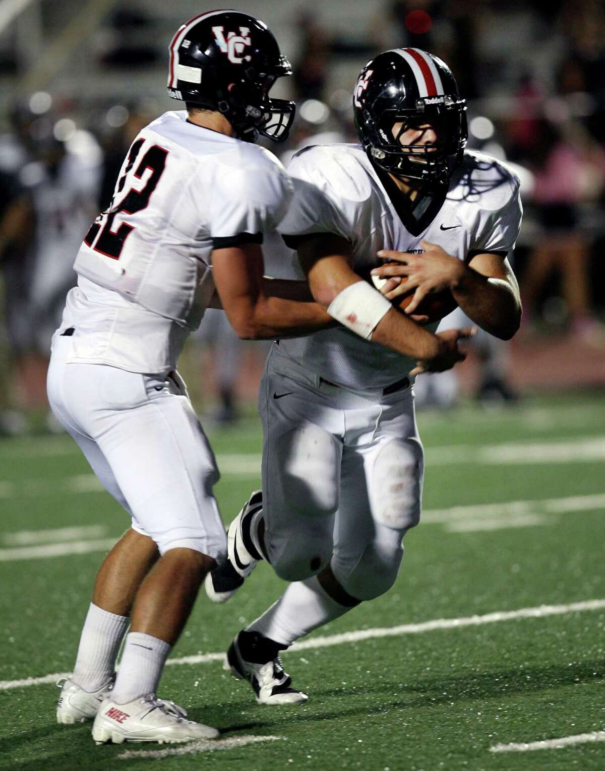 Churchill High School's Nate Peason passes off the ball to Nicholas Smisek during the first half of the game against Roosevelt Saturday, Oct. 26, 2013 at Comalander Stadium.