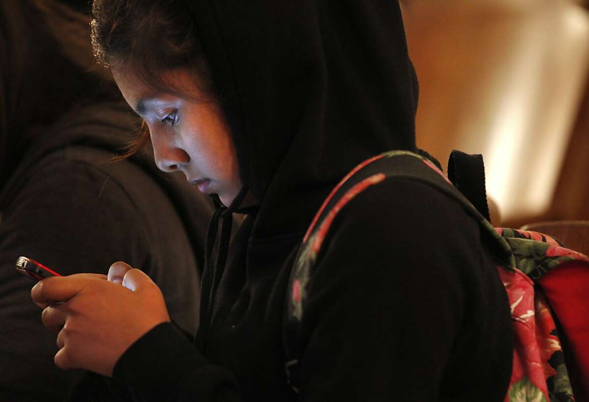 Maggie Urbina, 13, uses her phone before the "Stand Up, Don't Stand By: How to put an end to bullying in a 24/7 digital world" presentation and discussion put on by Common Sense Media October 22, 2013 at James Lick Middle School in San Francisco, Calif.