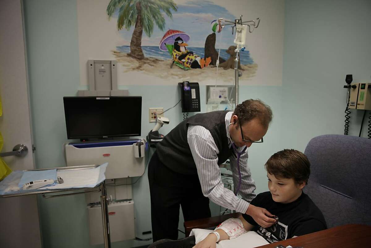 Dr. Steve Gitelman (left), who is working on a type of treatment to prevent people from becoming Type 1 diabetic when it runs in the family, examines Jonathan Marks (right), 13, as he receives an infusion that is part of the treatment research at the University of California, San Francisco outpatient Pediatric Clinical Research Center on Tuesday, October 22, 2013 in San Francisco, Calif.