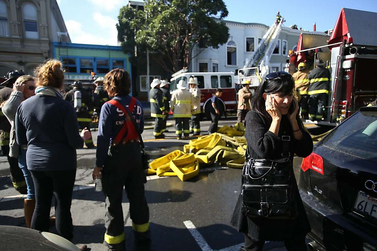 Nancy Myers, owner of a business affected by the three-alarm fire at 1448/1450 Valencia St. talks on her phone at the scene on Monday, Oct. 28, 2013.