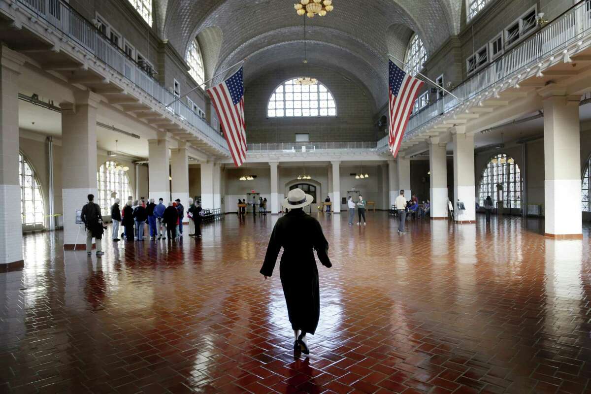 A park ranger walks through the registry room on Ellis Island after it was reopened ahead of Superstorm Sandy's anniversary.