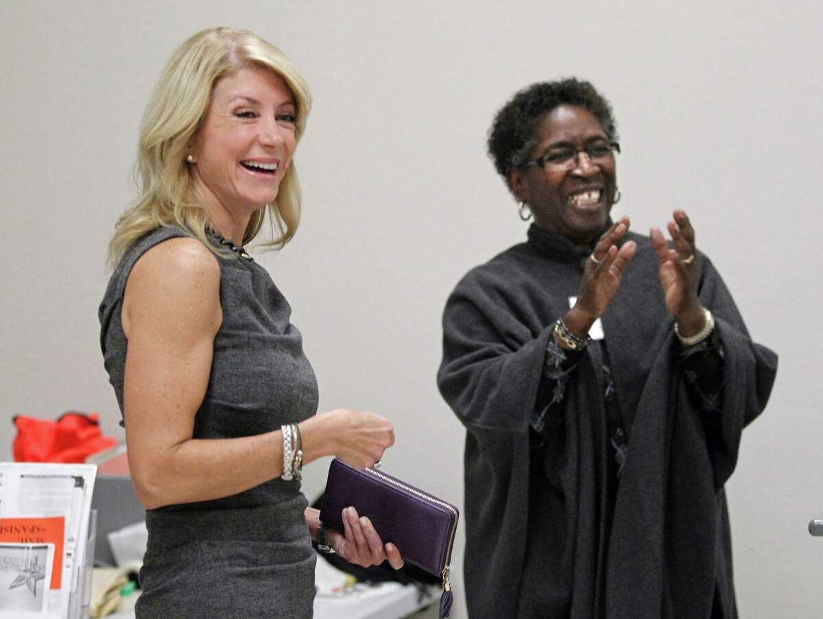 State Sen. Wendy Davis, left, visits Monday with lead clerk Melba Mackey and the staff at the Southside Community Center in east Fort Worth before she cast an early vote in Texas' Nov. 5 election.