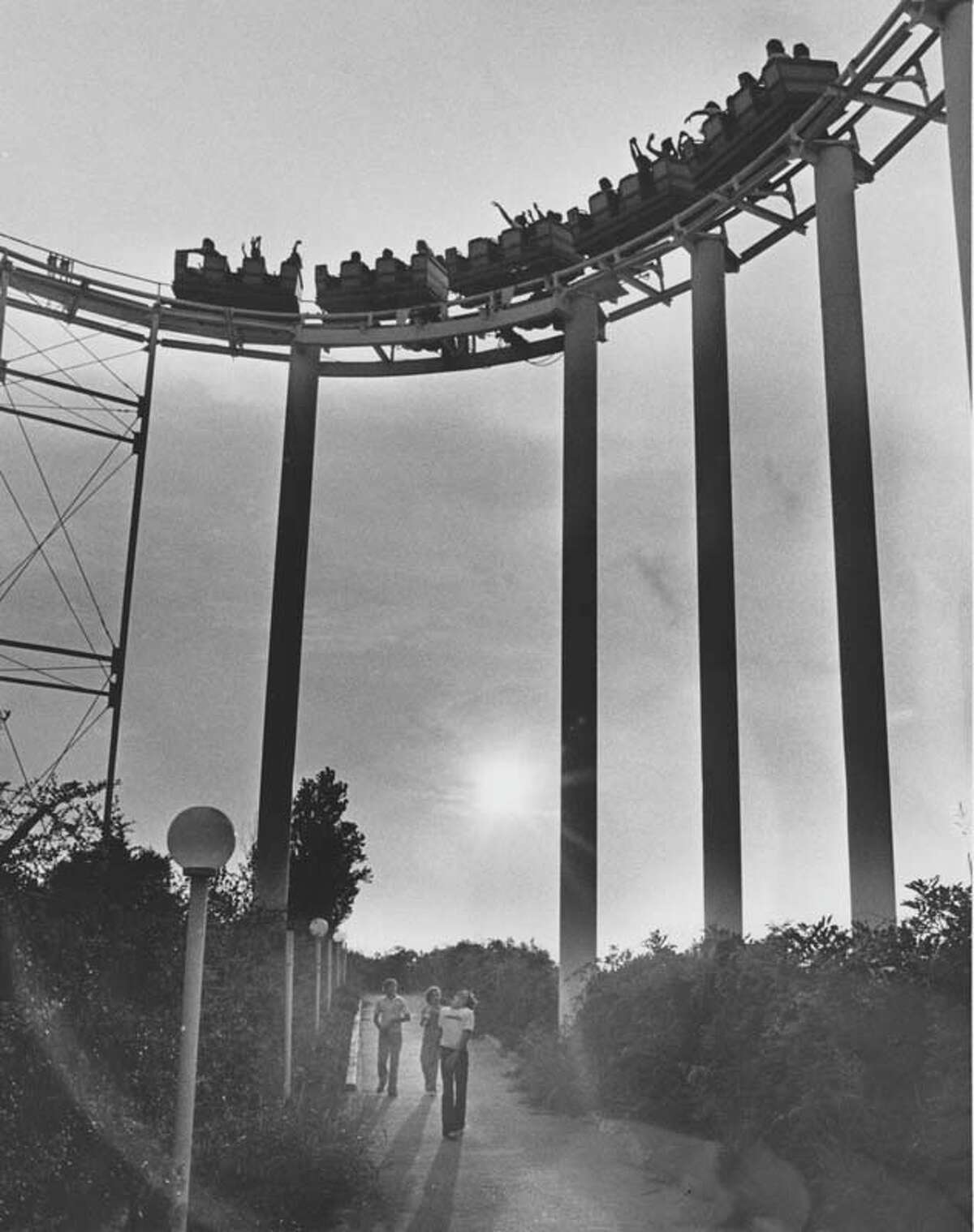 Passersby walk underneath AstroWorld's first major roller coaster, the Dexter Freebish Electric Roller Ride.