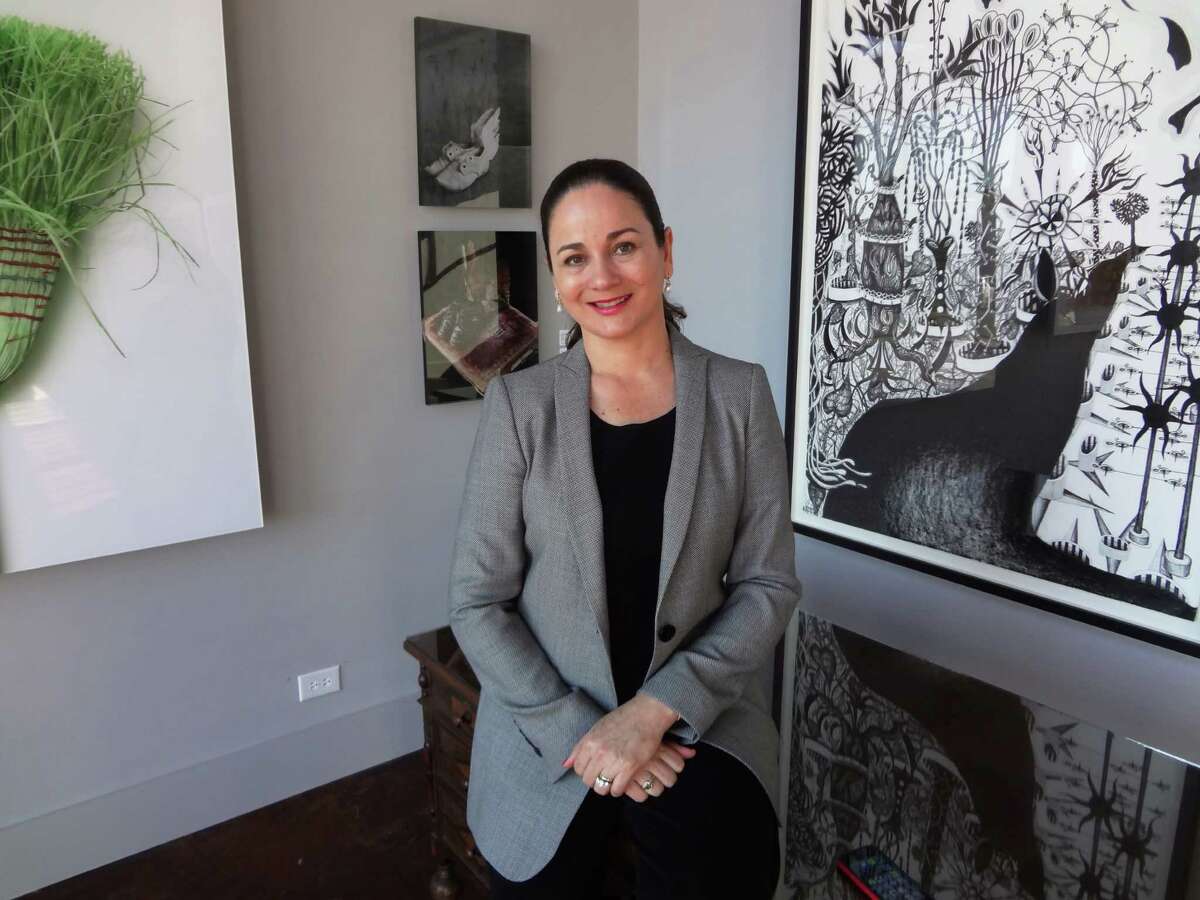 Patricia Ruiz-Healy, who has shown the work of artists in private exhibitions in her home, has opened a gallery, Ruiz-Healy Art, just off Olmos Circle. Behind her are works by Chuck Ramirez (from left), Cecilia Paredes and Nicolas Leiva.