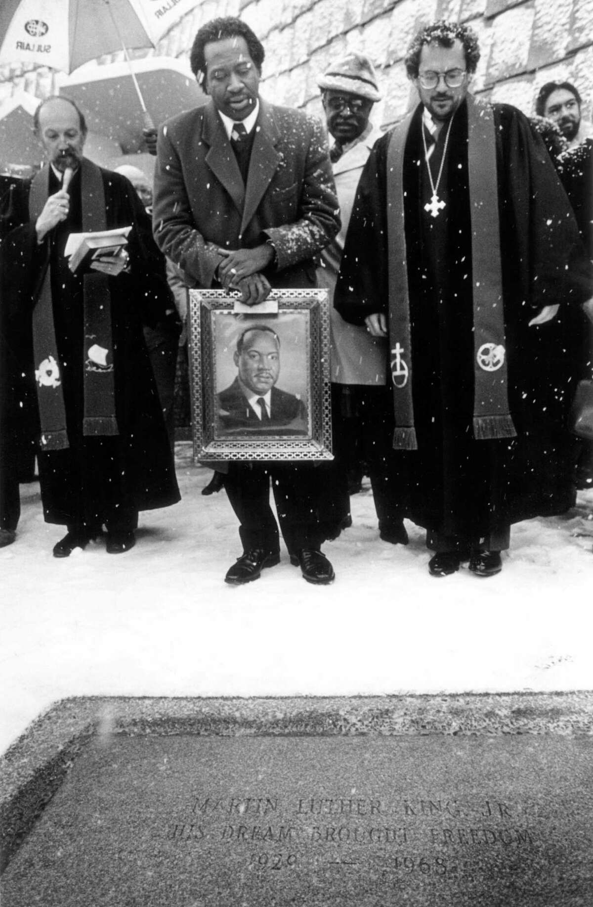 Jan/ 18, 1987: The Rev. Lorenzo Robinson holds a painting of the Rev. Dr. Martin Luther King Jr. while the Rev. Ronald James reads a statement dedicating a granite stone to the slain civil rights leader at the First Presbyterian Church in Stamford. The Rev. David Van Dyke, right, and the Rev. Sylvester Maultsba look on. Robinson dies Oct. 24, 2013.