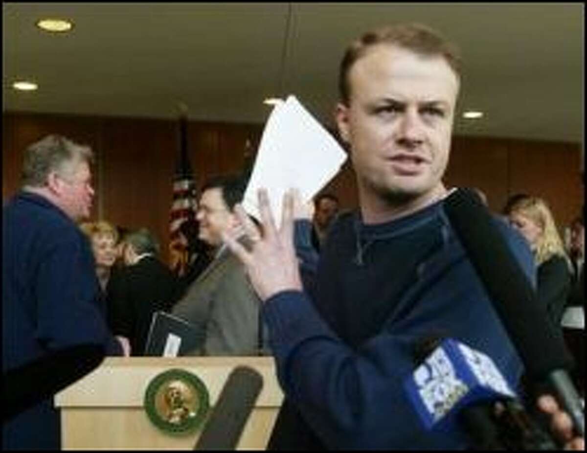 Tim Eyman in happier times, filing an initiative with the Secretary of State's office in Olympia.  The initiative promoter is facing a $2.1 million civil suit by the Attorney General's office, which charges he pocketed campaign funds for personal use.