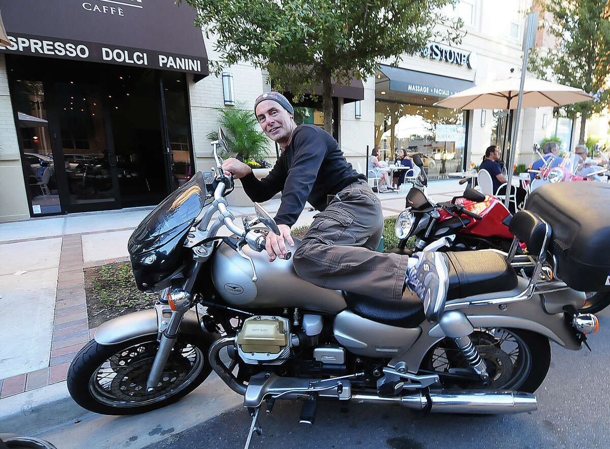 Claudio Arena parks his Italian motorcycle in front of Fellini Caffee. There have been times when every Fellini customer was speaking Italian, a co-owner says.