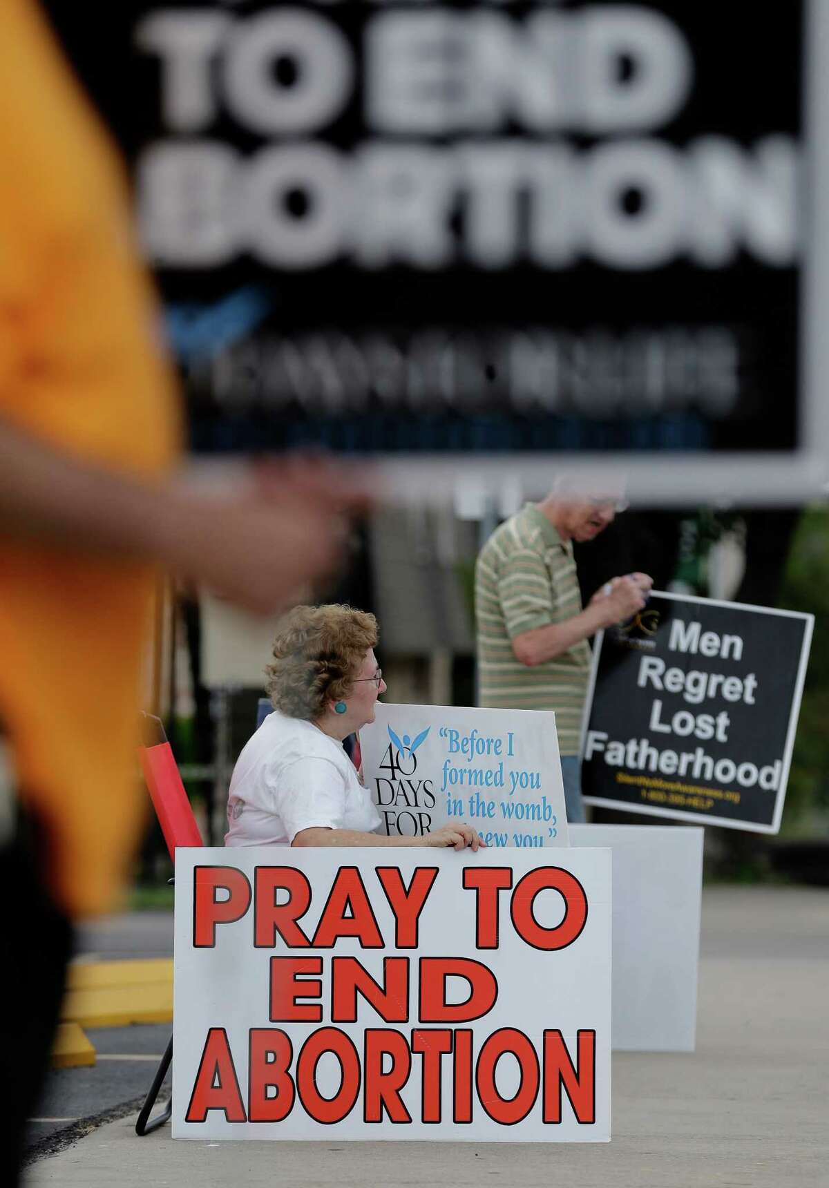 Dottie and Tom Knodell hold signs outside a Planned Parenthood Clinic in San Antonio on Tuesday. A federal judge is considering whether to grant an appeal letting Texas enforce a law that could shut down a dozen Texas abortion clinics.