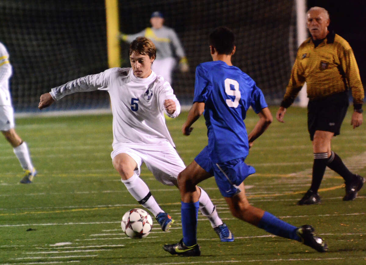 Newtown's Brenton Scott (5) controls the ball as Brookfield's Lucas Rodrigues (9) defends during the SWC boys soccer final at Bunnell High School in Stratford, Conn. on Wednesday, Oct. 30, 2013.