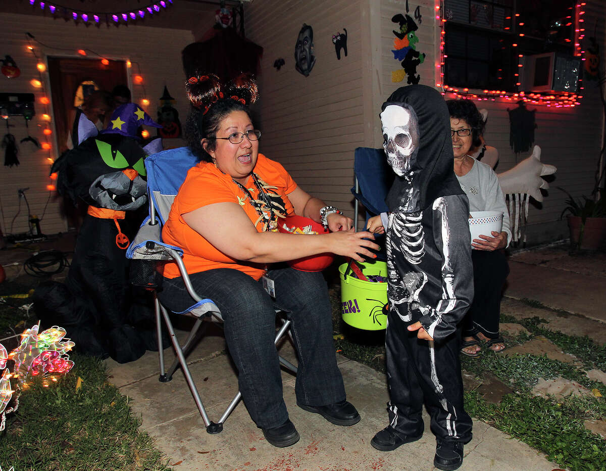 Cindy Castillo is entertained by a skeleton as kids go trick-or-treating on the Southeast Side on October 31, 2013.