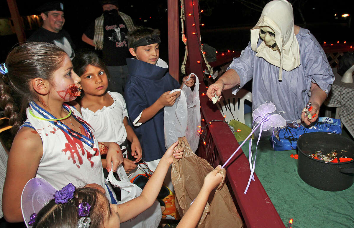 Corrine McGee hands out candy as kids go trick-or-treating on Hatcher Street on the Southeast Side on October 31, 2013.