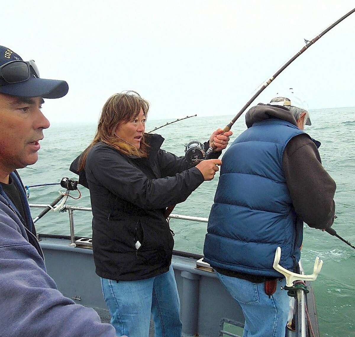 Jenna Tognoni battles a salmon as John Dresser, a deckhand and part-time captain of the Wacky Jacky out of San Francisco, looks on.