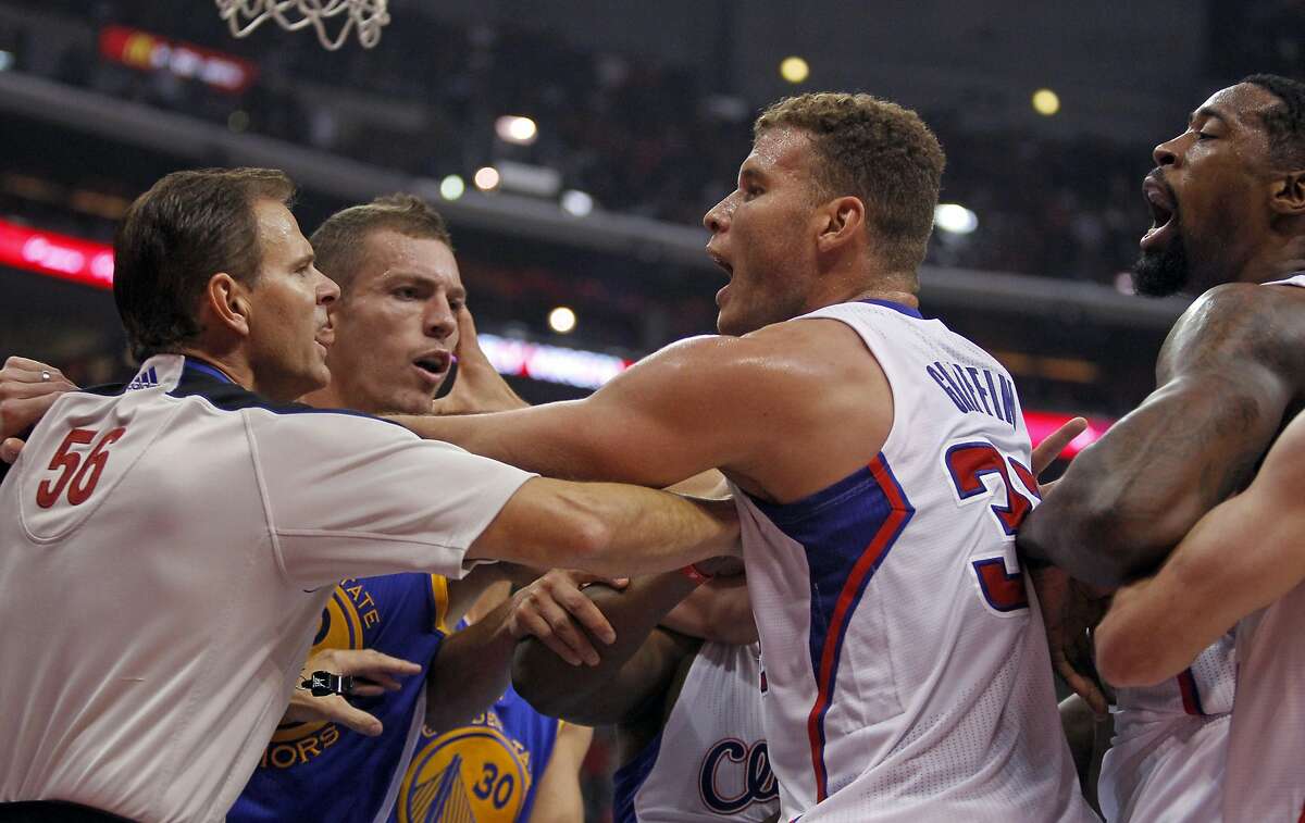 Referee Mark Ayotte, left, breaks up a scuffle between Los Angeles Clippers center DeAndre Jordan, right, and Golden State Warriors Andrew Bogut (not shown) with Clippers forward Blake Griffin, center, trying to keep the peace with Warriors forward David Lee, second from left, in the second quarter during an NBA basketball game on Thursday, Oct. 31, 2013, in Los Angeles. (AP Photo/Alex Gallardo)
