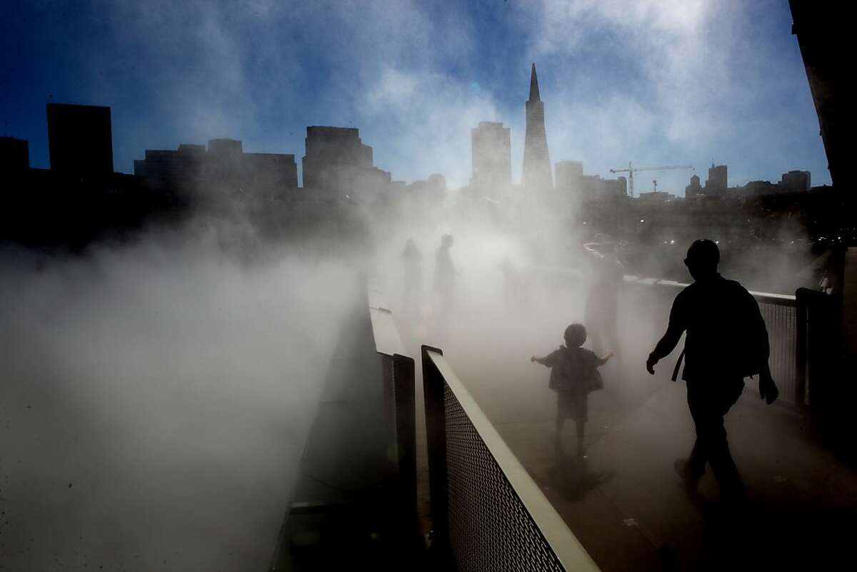 Visitors to the "Fog Bridge" on Saturday September 28, 2013, was created by artist Fujiko Nakaya, which occupies the pedestrian bridge between Piers 15 and 17 at the Exploratorium in San Francisco, Calif.