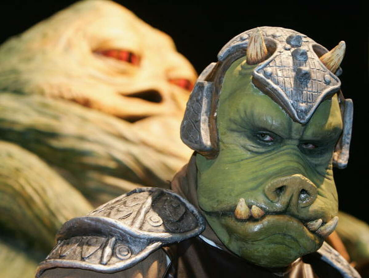 A person in costume as a Gammorean Guard in front of a model of Jabba at the Celebration Europe Exhibition in Excel Centre on July 13 in London, England. The Star Wars Celebration Europe commemorates the first 30 years of the most successful film series to date.