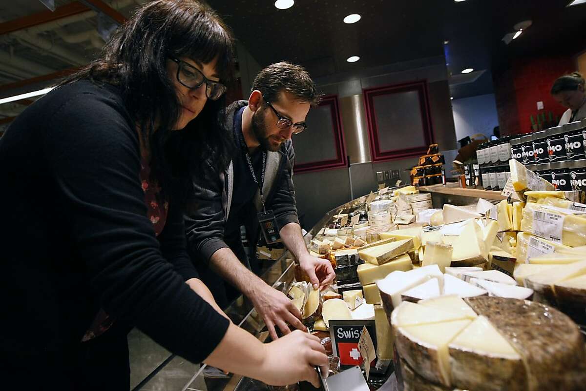 Hayley Gaines, left, and Chris Chandler stock the cheese case as they help prepare for the grand opening of the new Whole Foods Market on the corner of Market St. and Dolores St. in San Francisco, CA Friday, November 1, 2013.
