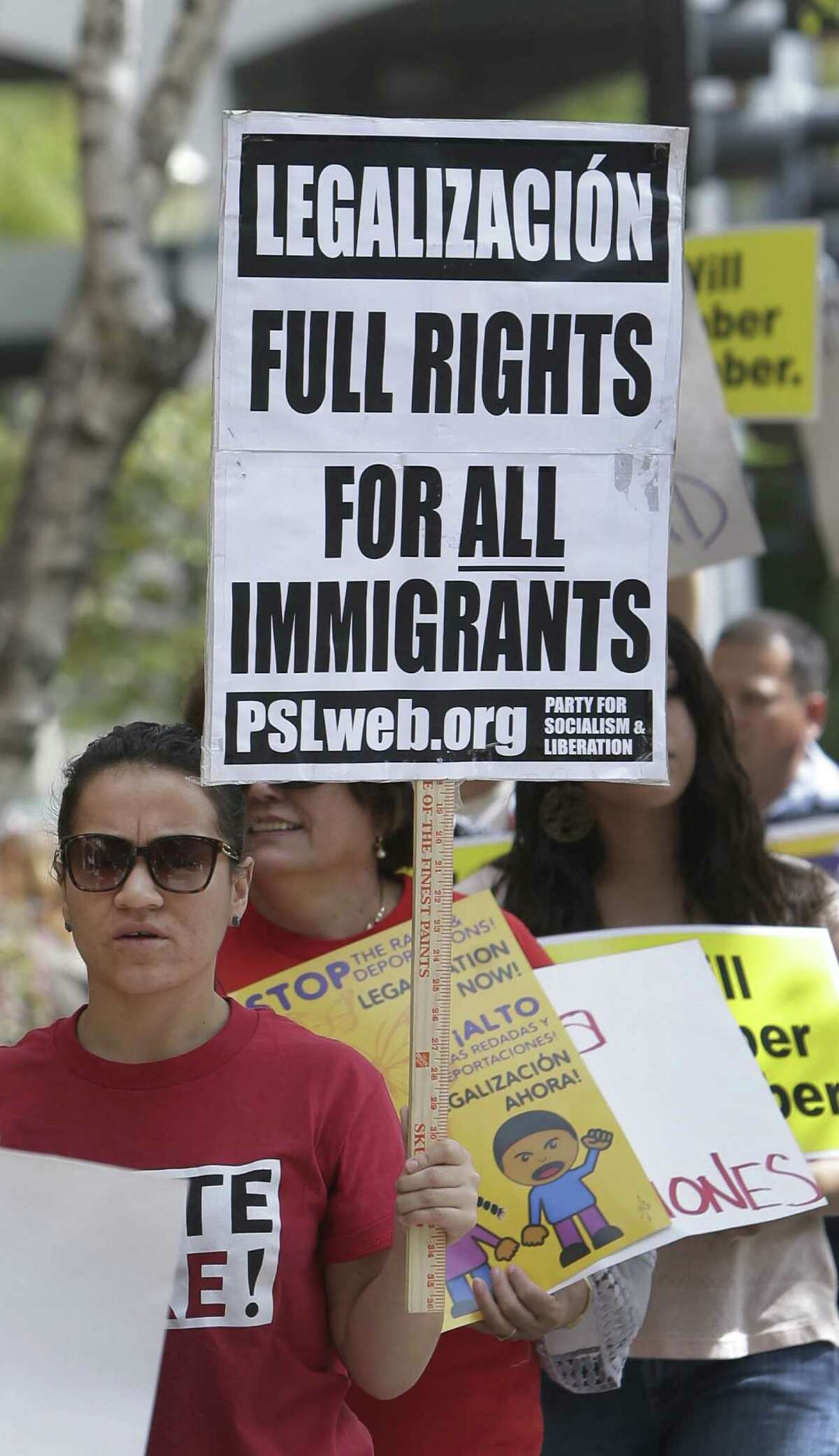 More than two dozen immigrant-rights advocates, students, labor and community activists march Tuesday outside the state Republican Party Headquarters in Sacramento, Calif.
