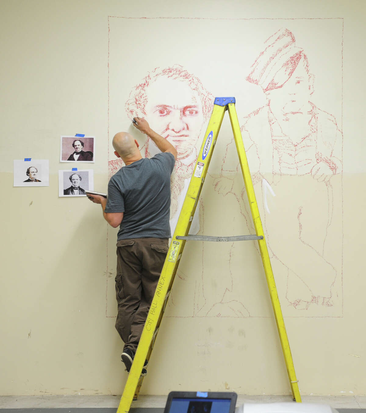New York artist Roberto Martinez works on a stamp mural of P.T. Barnum and Tom Thumb in the former Probate CourtâÄôs vault Tuesday, Oct. 29, 2013 at McLevy Hall in downtown Bridgeport, Conn. The historic building will become a new home for artists beginning on Nov. 7 thanks to a state-city grant-funded partnership that will provide space for artists to create and sell their artwork from inside the building.