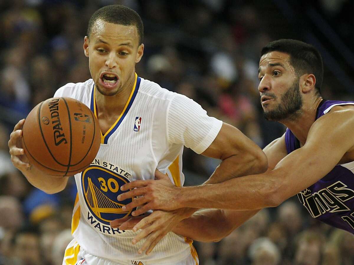 Warriors' Stephen Curry, left, drives the ball around Kings' Greivis Vasquez November 2, 2013 during the Warriors vs. Kings game at the Oracle Arena in Oakland, Calif.