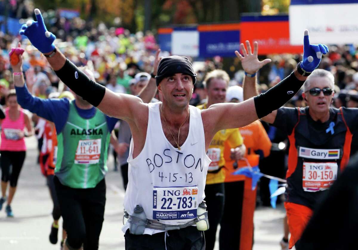 A runner in Sunday's New York City Marathon pays tribute to victims of the Boston Marathon bombings as he crosses the finish line.