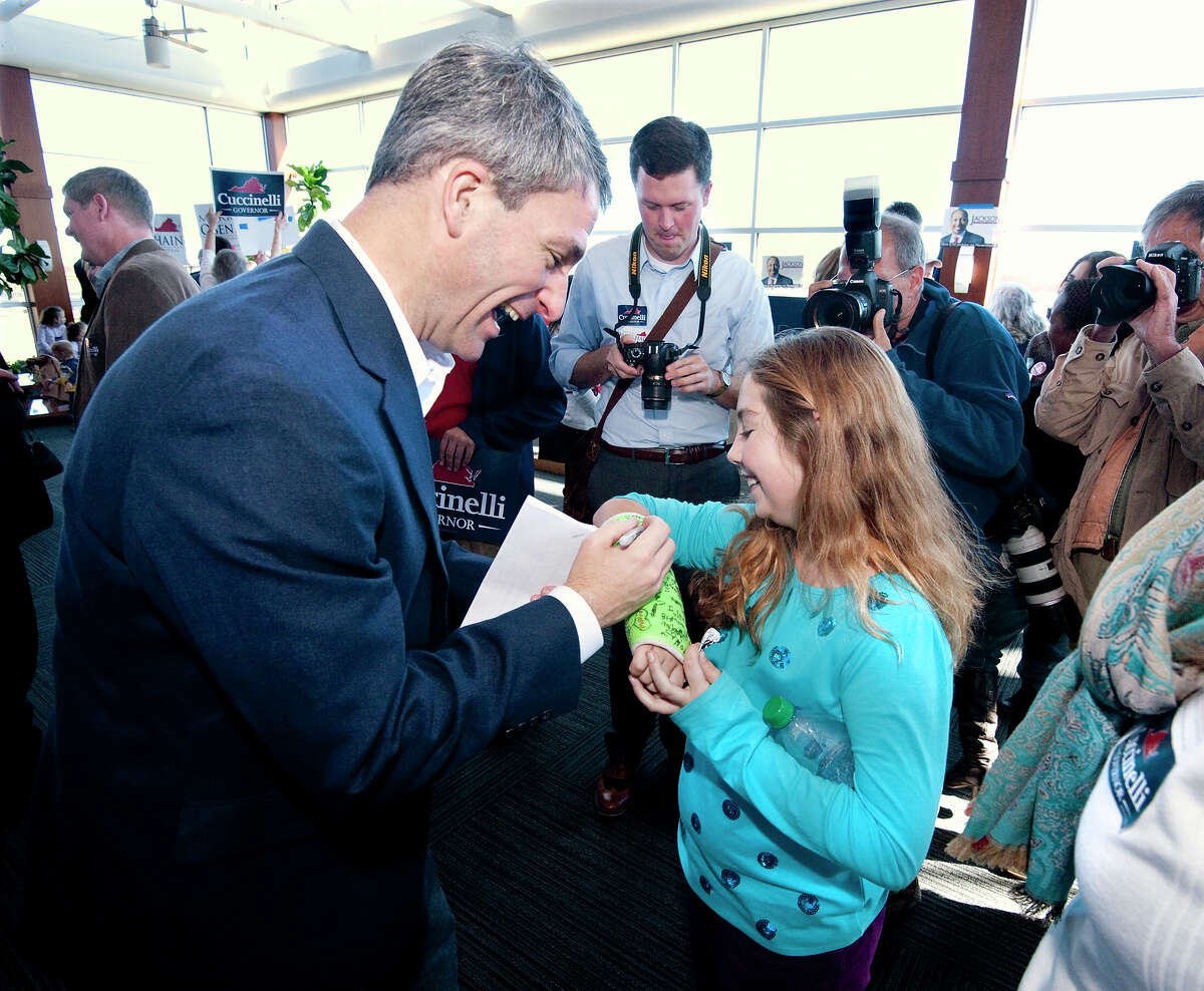 Courtney Begoon, 9, from Crimora, Va., has her arm cast autographed by Republican gubernatorial candidate Ken Cuccinelli after a campaign rally at the Shenandoah Valley Regional Airport.