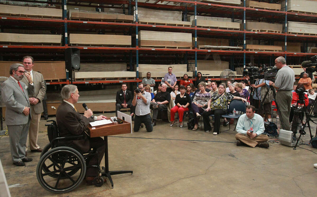 Texas Attorney General Greg Abbott, at lectern, left, talks with employees at Steves & Sons, a South Side door-making company, and others last Thursday. Abbott, a Republican, is running for governor.