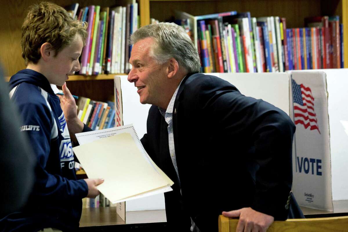 Virginia Democratic gubernatorial candidate Terry McAuliffe, right, turns toward his son Peter after completing his vote on election day in McLean, Va. on Tuesday, Nov. 5, 2013. (AP Photo/Jacquelyn Martin)