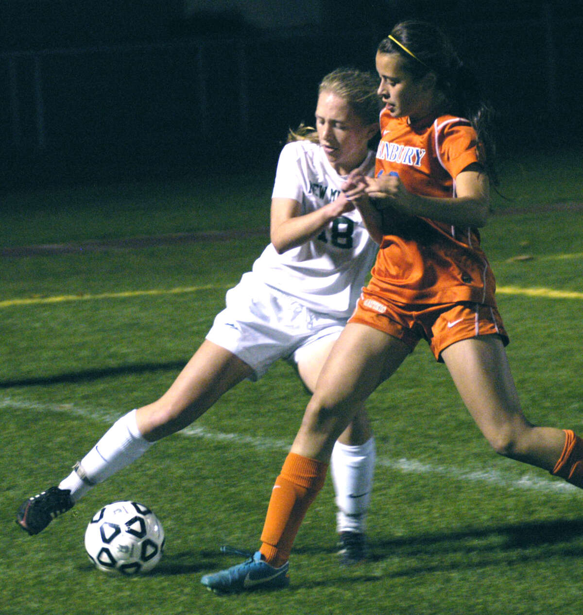 Helen Bayers of the Green Wave battles a Danbury player for possession deep in New Milford territory during Wednesday's state tournament match at NMHS. Nov. 6, 2013