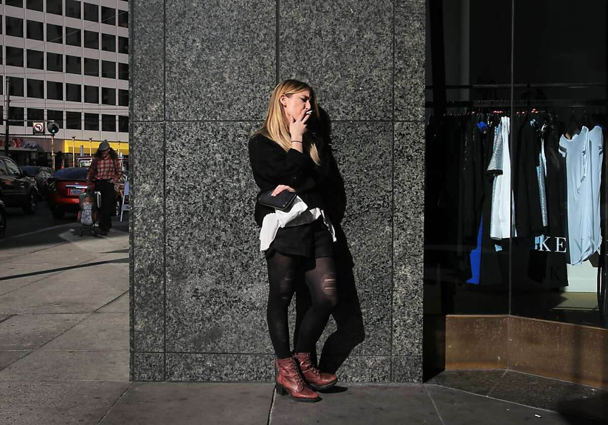 Alexis Bowles, 23, smokes a cigarette during her break from a job in Westfield Mall November 7, 2013 in downtown San Francisco, Calif. Those who wish to increase the tax on cigarettes to pay for cancer research are collecting signatures again after a narrow defeat at the ballot box last year.