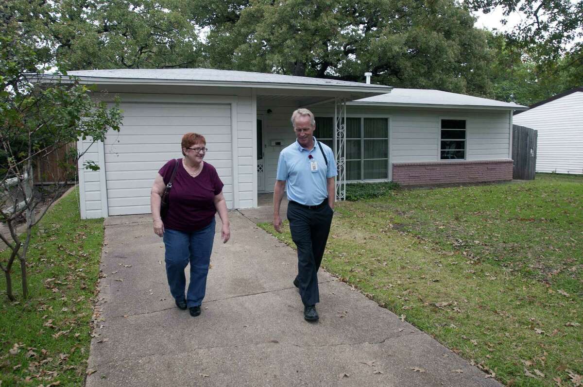 Irving city officials Shirley Smith (left) and Kevin Kendro leave a home where Lee Harvey Oswald's wife and kids lived.