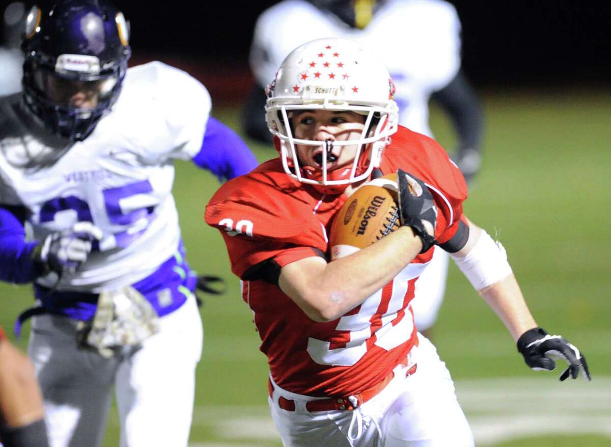 At right, Greenwich running back Thomas Rappa (# 30) gets past Zac Cowit (# 35) of Westhill during the high school football game between Greenwich High School and Westhill High School at Greenwich, Friday, Nov. 8, 2013.