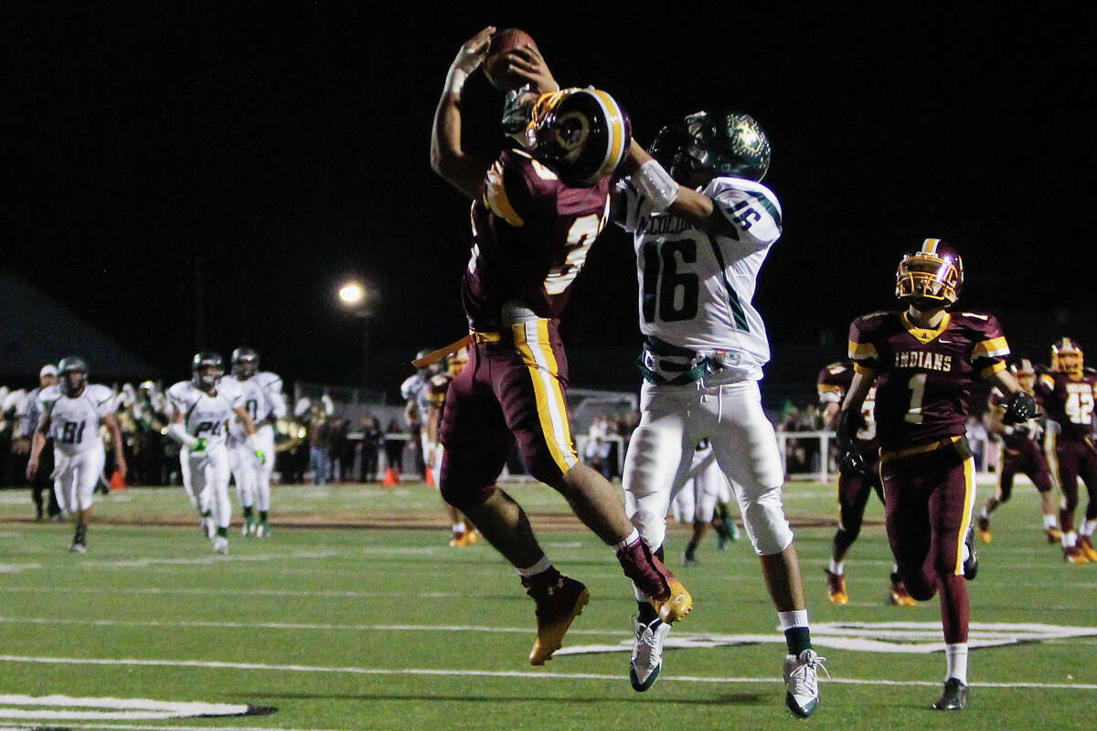 Harlandale's Vicgtory Flores (center left) breaks up a pass intended for McCollum's Justin Villanueva during the first half of the 50th annual Frontier Bowl between Harlandale and McCollum at Harlandale Memorial Stadium on Friday, Nov. 8, 2013. MARVIN PFEIFFER/ mpfeiffer@express-news.net