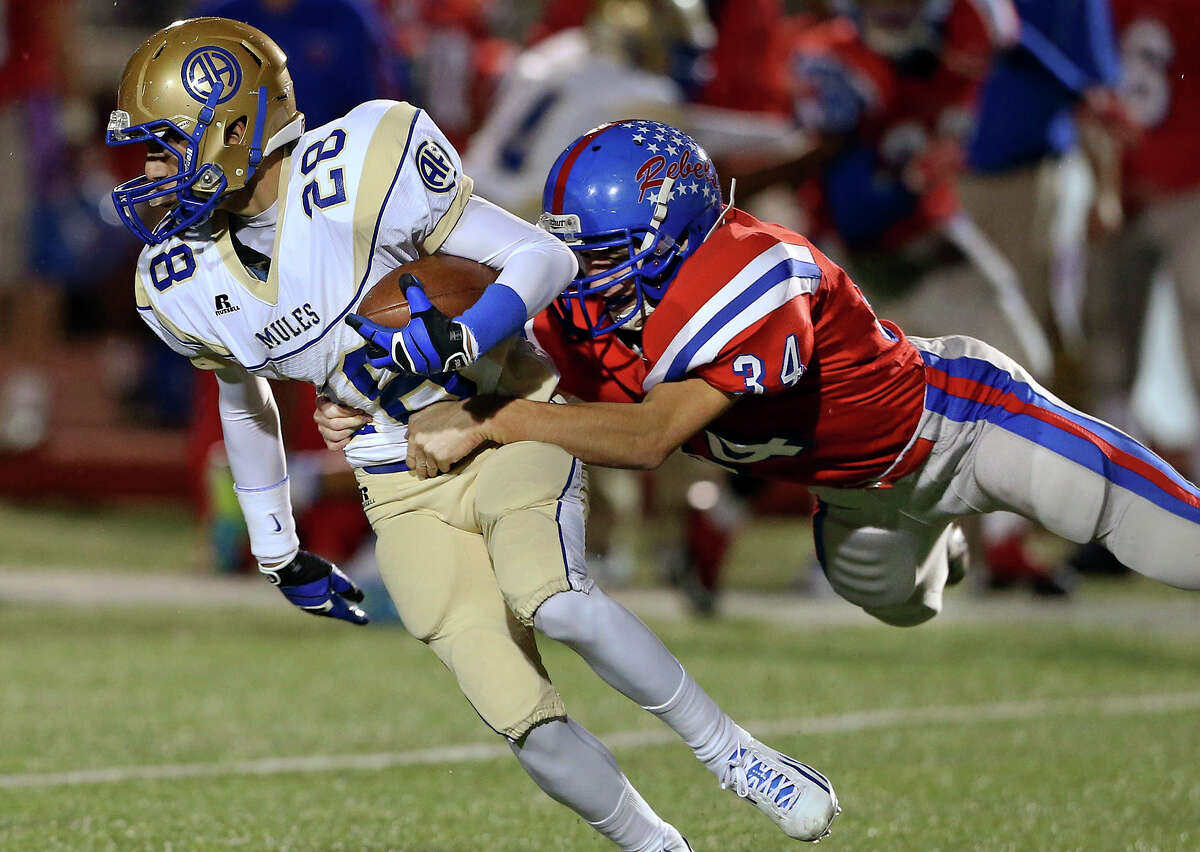 Anthony Sotelo is caught on a flying leap by the Rebels' Eric Gronbach as Hays hosts Alamo Heights at Bob Shelton Stadium on November 8, 2013.