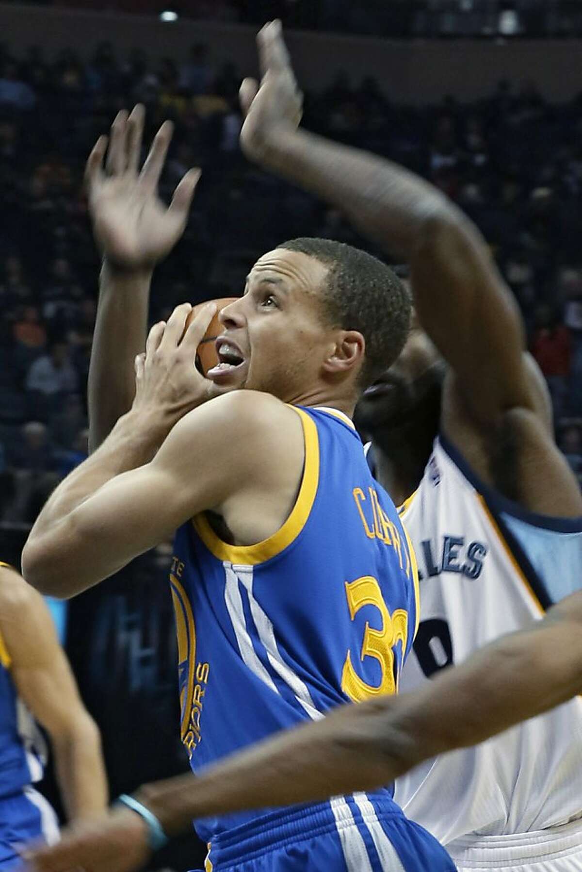 Golden State Warriors guard Stephen Curry goes to the basket in front of Memphis Grizzlies defenders in the first half of an NBA basketball game in Memphis, Tenn., Saturday, Nov. 9, 2013. (AP Photo/Danny Johnston)