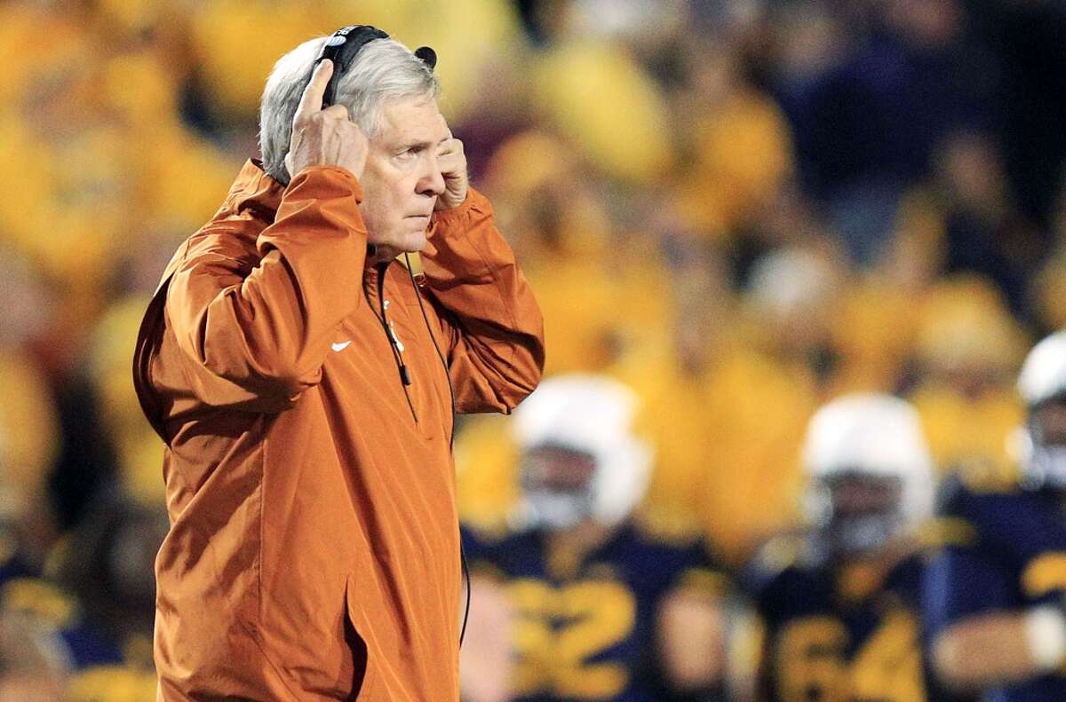 Texas coach Mack Brown walks across the field after an injury to one of his players in the second quarter of an NCAA college football game against West Virginia in Morgantown, W.Va., on Saturday, Nov. 9, 2013. Texas won 47-40 in overtime. (AP Photo/Christopher Jackson)