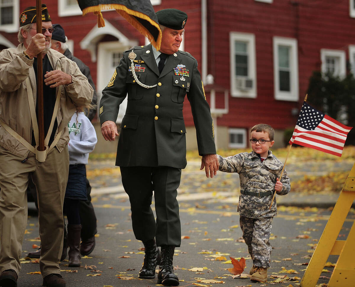 Wyatt Gaffney, 3, marches with his grandfather, Vietnam veteran Tom Johnson, of Milford, in the Veteran's Day Parade in Milford, Conn. on Sunday, November 10, 2013.