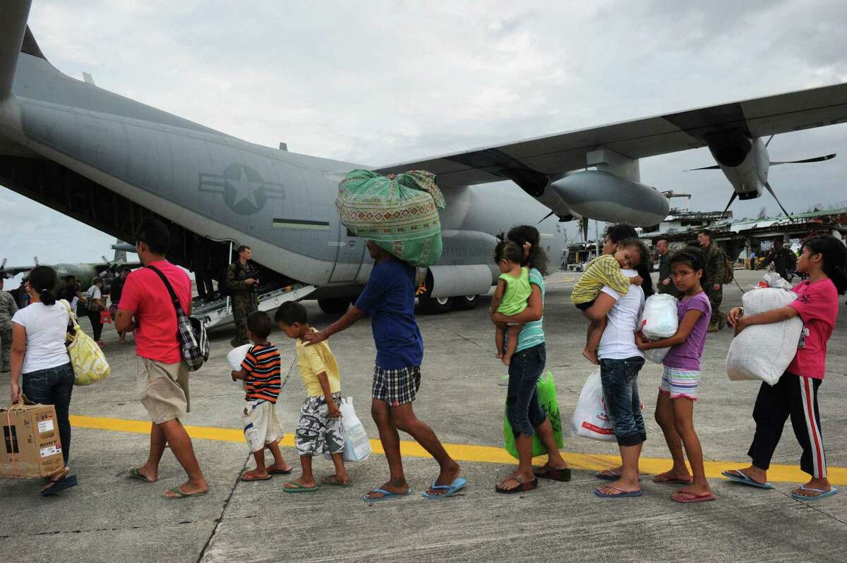 Survivors of Typhoon Haiyan in Tacloban, Philippines, line up to board a U.S. military cargo plane. Members of a Catholic church in San Antonio are in the planning stages of sending aid to victims of the disaster.