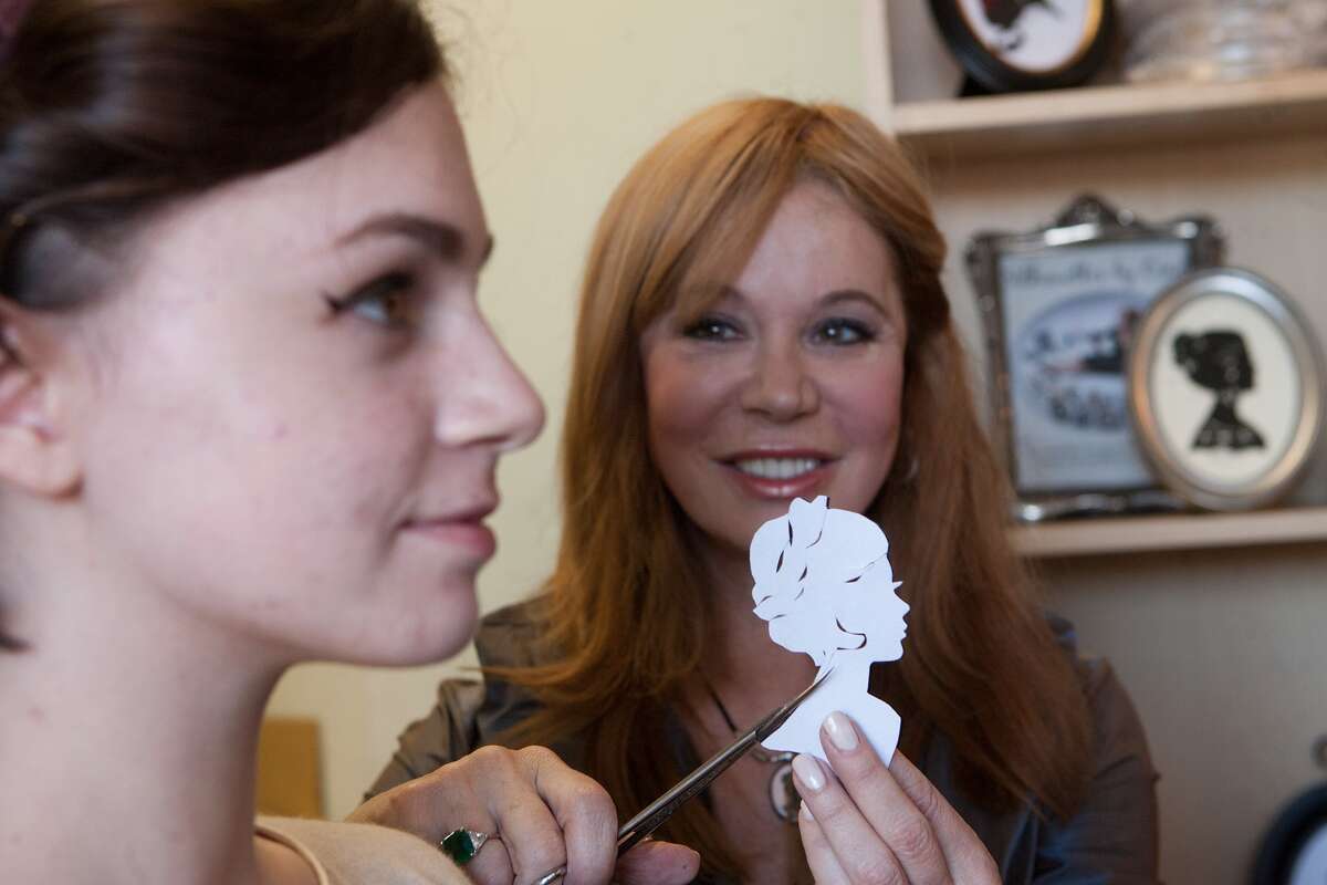 Anneysa Gaille, 16, poses as silhouette artist Cindi Rose (77024) does her thing at Fundamentally Toys in University Village. Photo By R. Clayton McKee