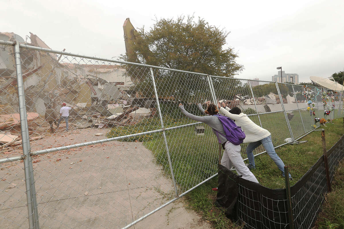 Protesters attempt to take a fence down at the former Univision building after Judge Janet Littlejohn ruled to dissolve a temporary restraining order, Tuesday, Nov. 12, 2013. It cleared the way for demolition to continue. It cleared the way for demolition to continue. Developing company, Greystar, plans on building a $55-million 355-unit apartment on the site. Eight protesters were arrested trying to stop the demolition.