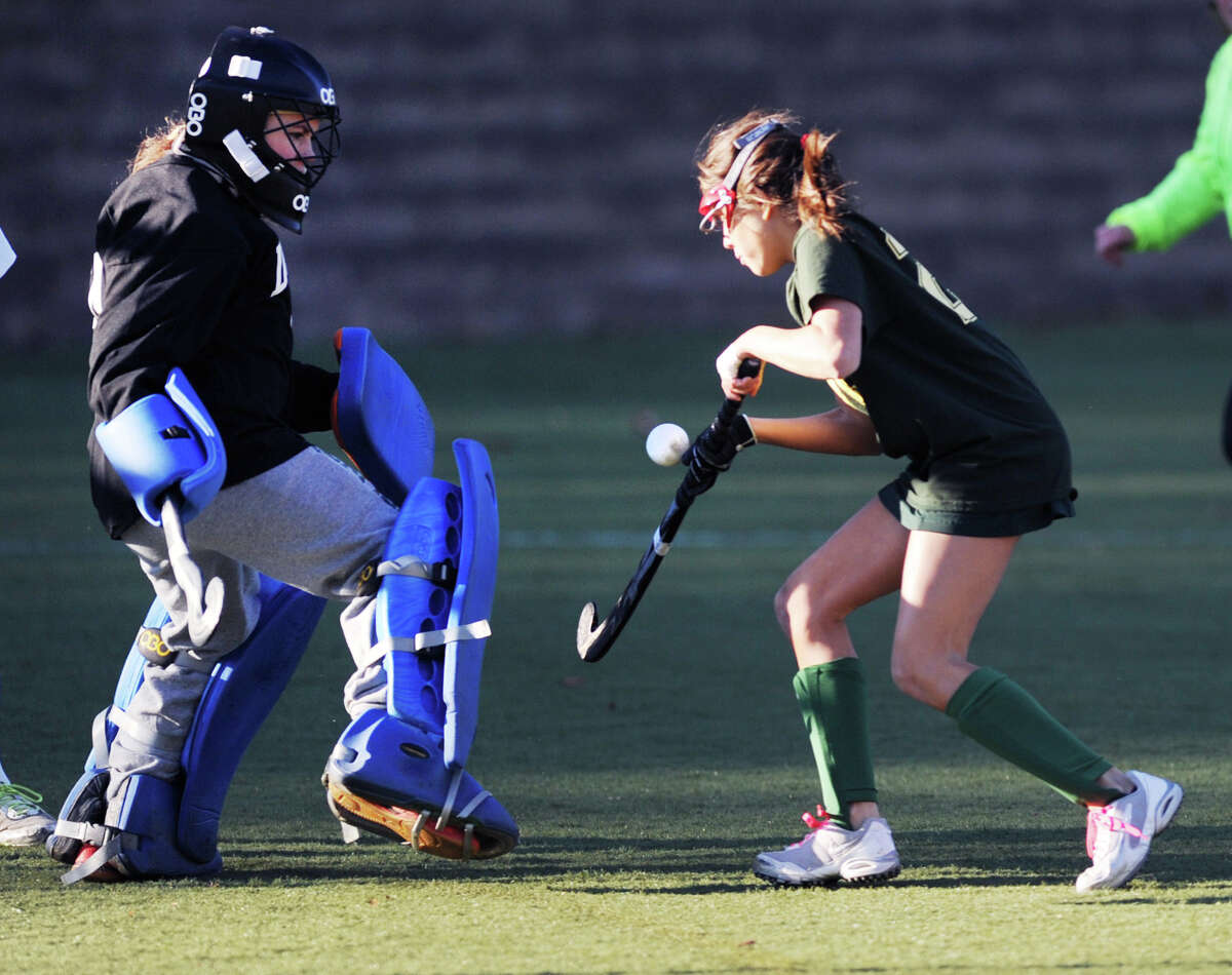 At right, Tati Viola (# 21) of Greenwich Academy plays a rebound that is being defended by Deerfield goalie Katherine Heaney, left, during the girls high school field hockey playoff game between Greenwich Academy and Deerfield Academy at Greenwich, Wednesday afternoon, Nov. 13, 2013. Viola did not score on the play.