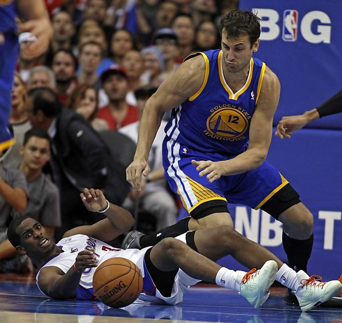 Los Angeles Clippers guard Chris Paul, left, battles Golden State Warriors center Andrew Bogut (12), of Australia, for the ball in the fourth quarter during an NBA basketball game on Thursday, Oct. 31, 2013, in Los Angeles. The Clippers won the game 126-115. (AP Photo/Alex Gallardo)