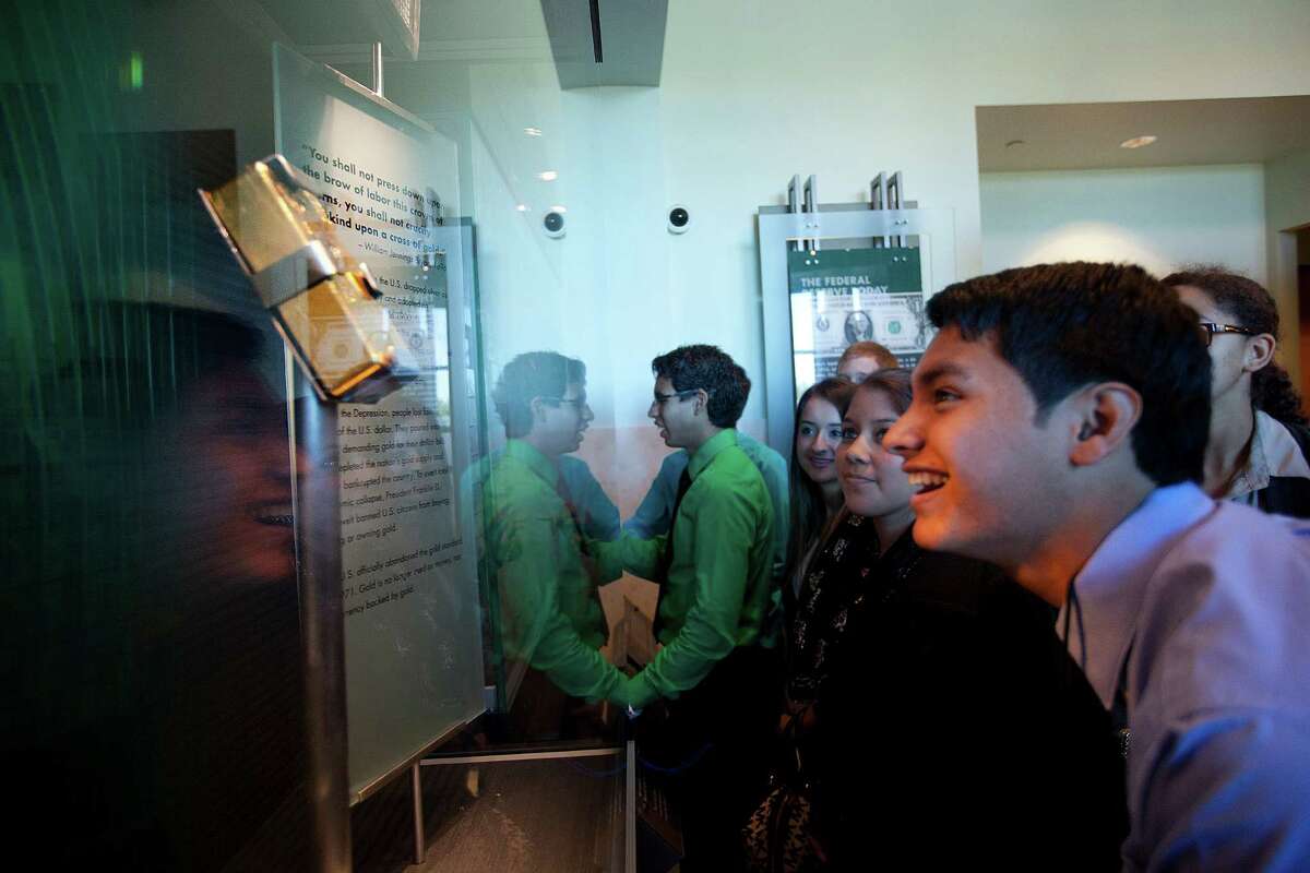 A gold ingot brings a glow to the face of Ricardo Gomez, a Sam Rayburn High School senior on a tour of the bank Wednesday.