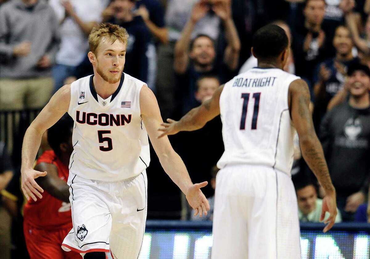 Connecticut's Niels Giffey, left, and Ryan Boatright celebrate a basket by Giffey during the first half of an NCAA college basketball game Thursday, Nov. 14, 2013, in Storrs, Conn.