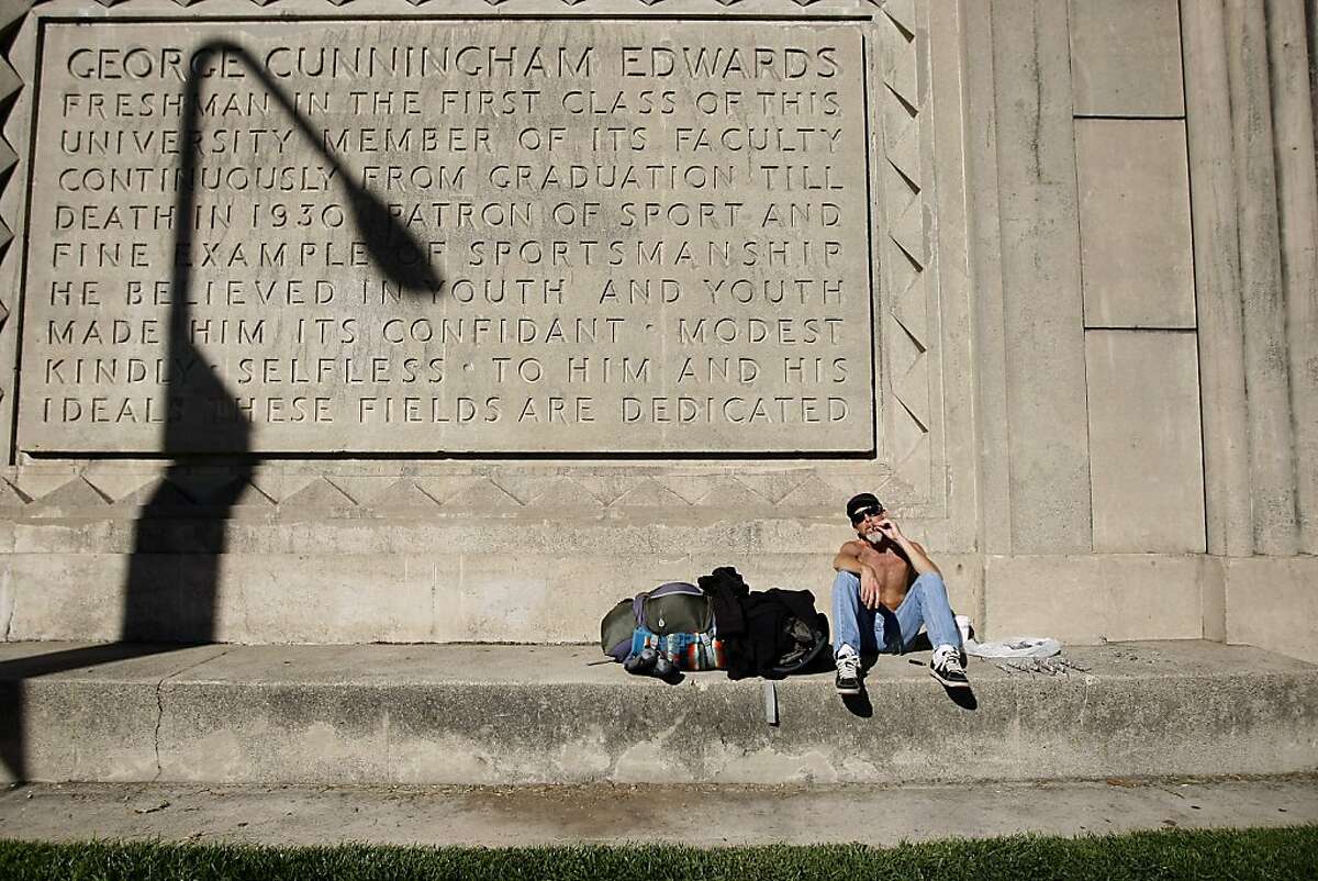 Self proclaimed urban camper Jonathan Dignes smokes as he soaks up some sun on the side of Edwards Stadium on the Cal campus in Berkeley, CA Wednesday, November 13, 2013.