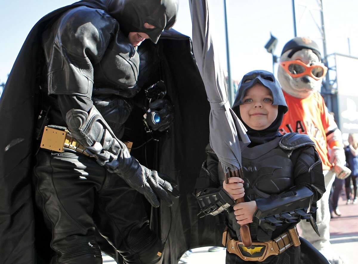 Batman and Batkid display the umbrella taken from the Penguin who kidnapped SF Giants mascot Lou Seal at AT&T Park in San Francisco Ca., on Friday Nov. 15, 2013. Five year old Miles from Tulelake in Siskiyou County loves superheroes and Batman in particular. After battling leukemia since he was a year old Miles will fulfill his dream of becoming Batkid being swept around the city performing superhero feats from rescuing a damsel in distress to thwarting a bank robbery and even chasing down the Penguin through AT&T Park