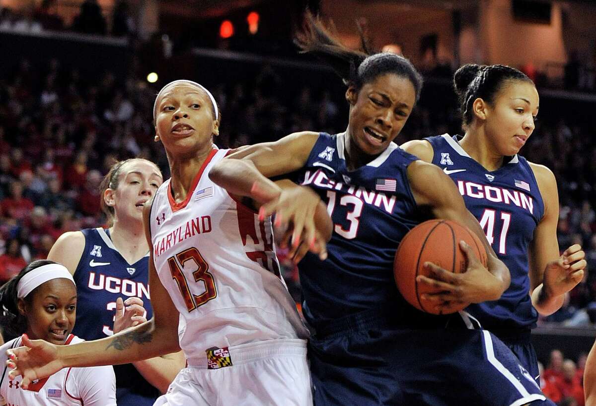 Connecticut's Brianna Banks, left, and Maryland's Alicia DeVaughn, right, reach for the ball in the second half of an NCAA basketball game Friday, Nov. 15, 2013 in College Park, Md.