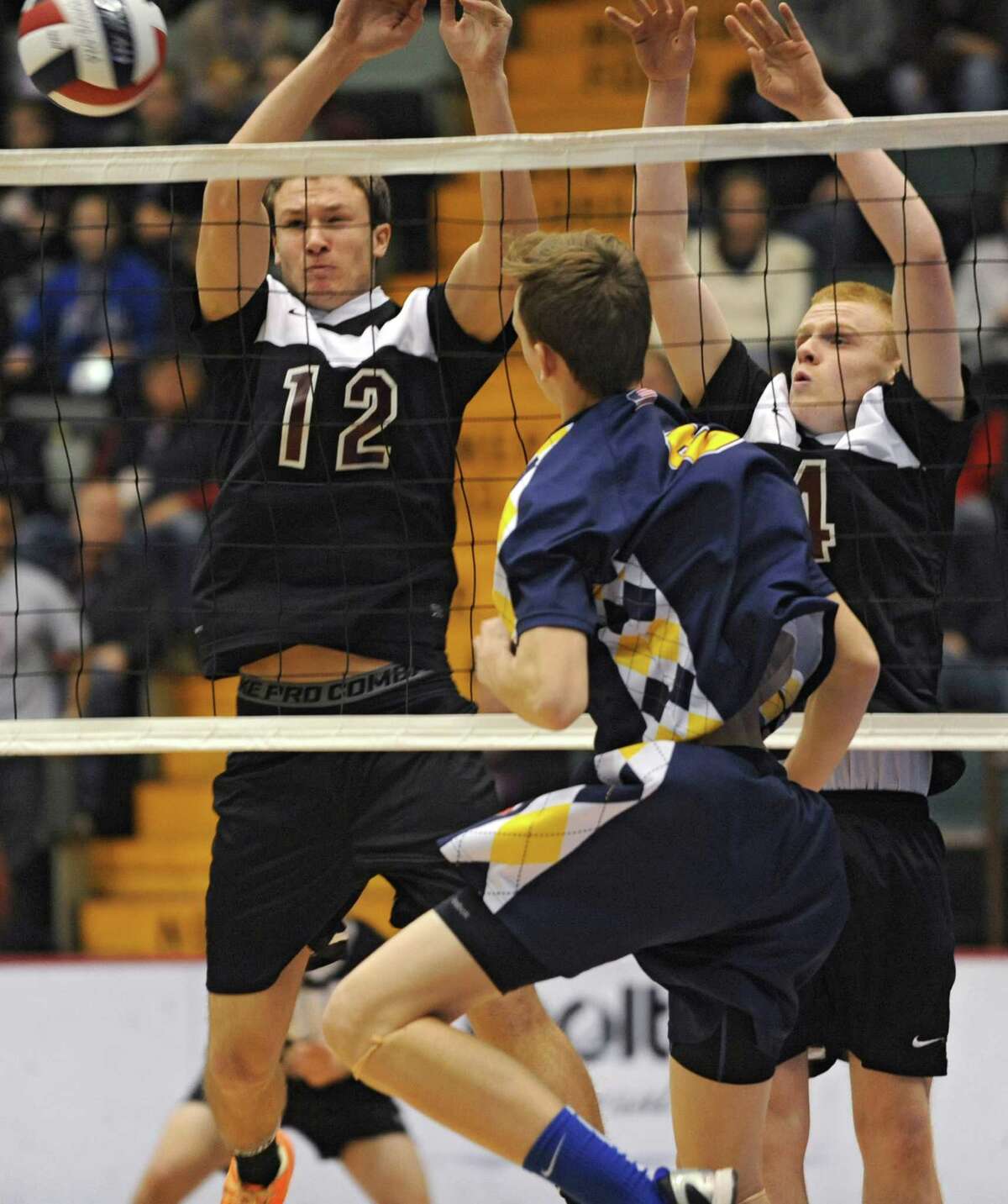 Austin Nydegger, left, and Ben Keppler, right, of Burnt Hills try to block the ball hit by Matt Erickson of Sachem during a state semifinals volleyball match on Friday, Nov. 15, 2013 in Glens Falls, N.Y. (Lori Van Buren / Times Union)